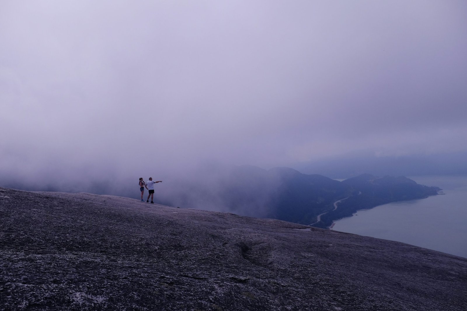 a couple of people standing on top of a mountain